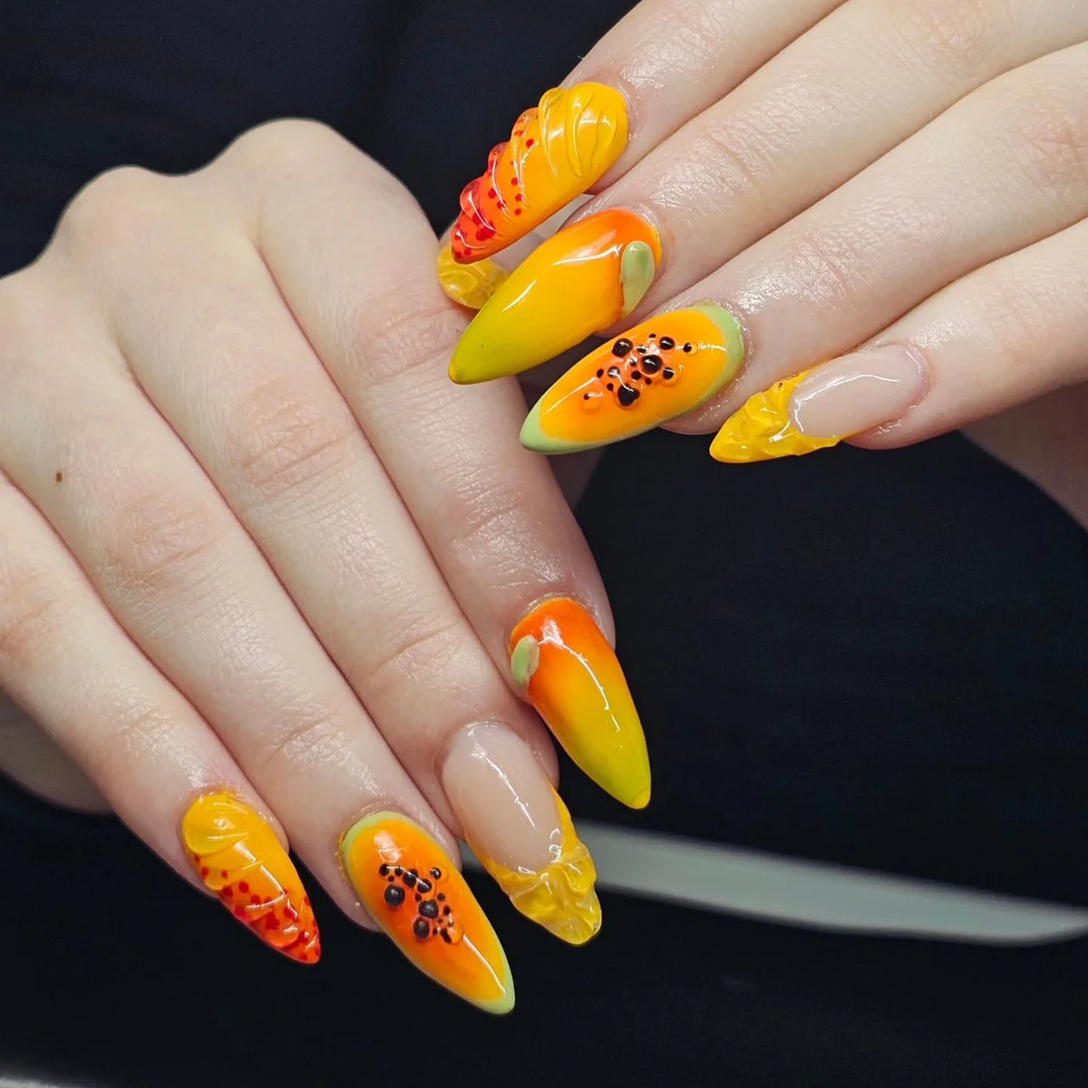 Yellow and orange nails with floral and glitter accents