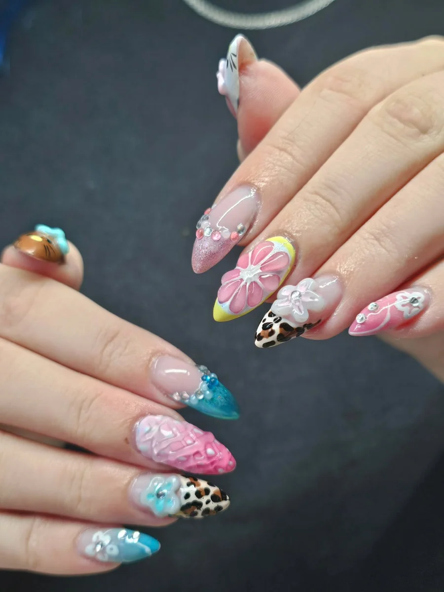 Long nails with colourful floral designs and glitter accents