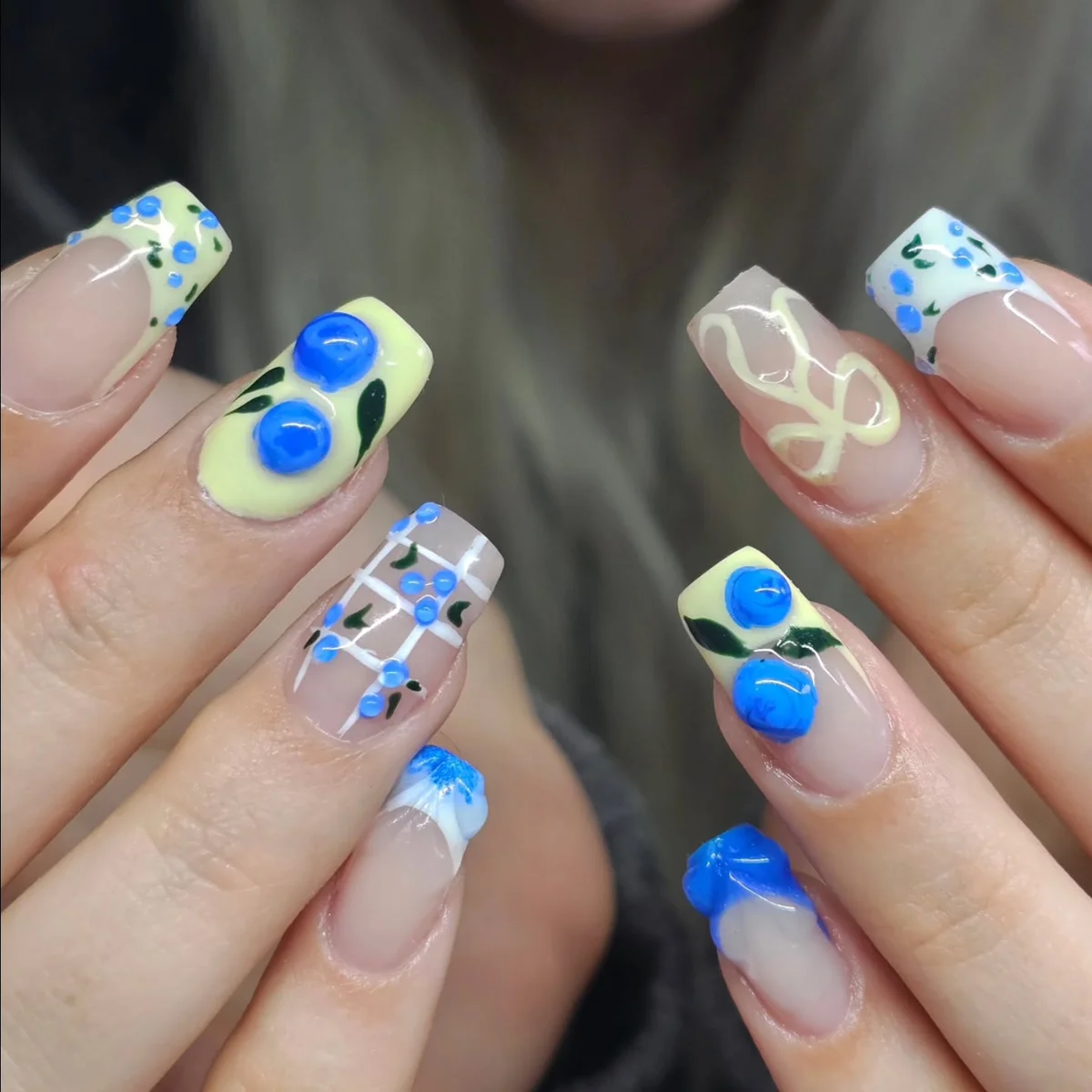 Blue and white nails with raised blue circles and patterned accents