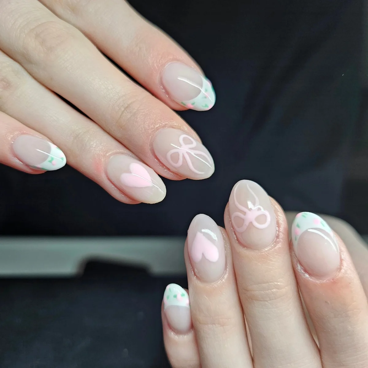 Pale pink nails with soft blue tips and white swirl designs
