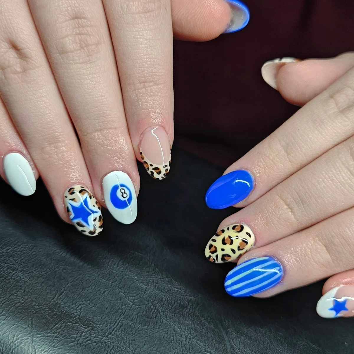 Blue, white and yellow nails with contrasting stars, swirls and patterns