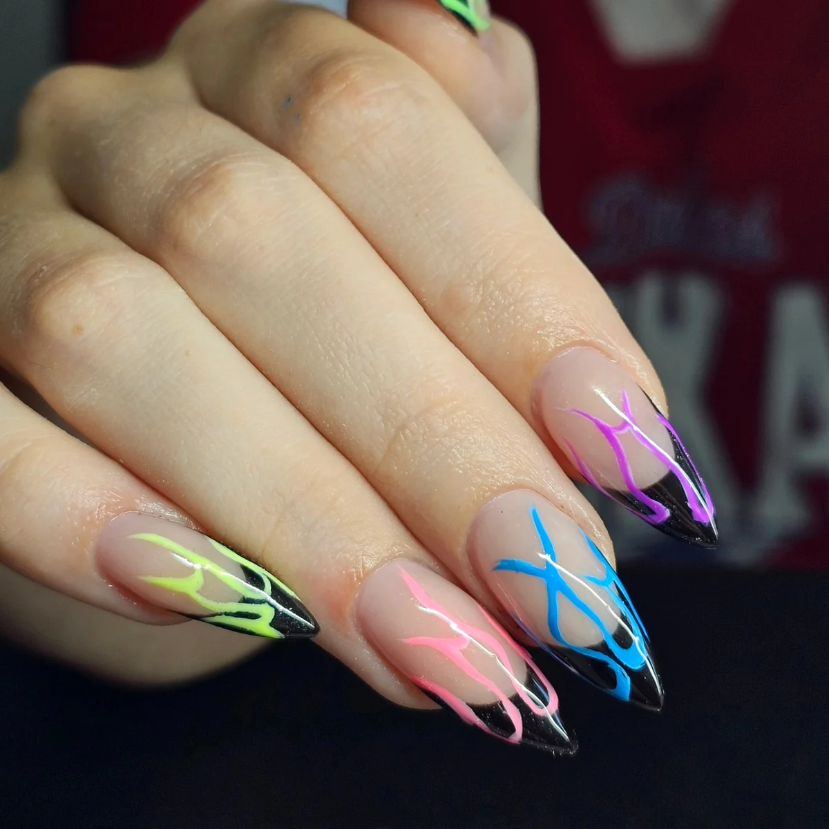 Nude nails with vivid pink, green, blue and purple line tips