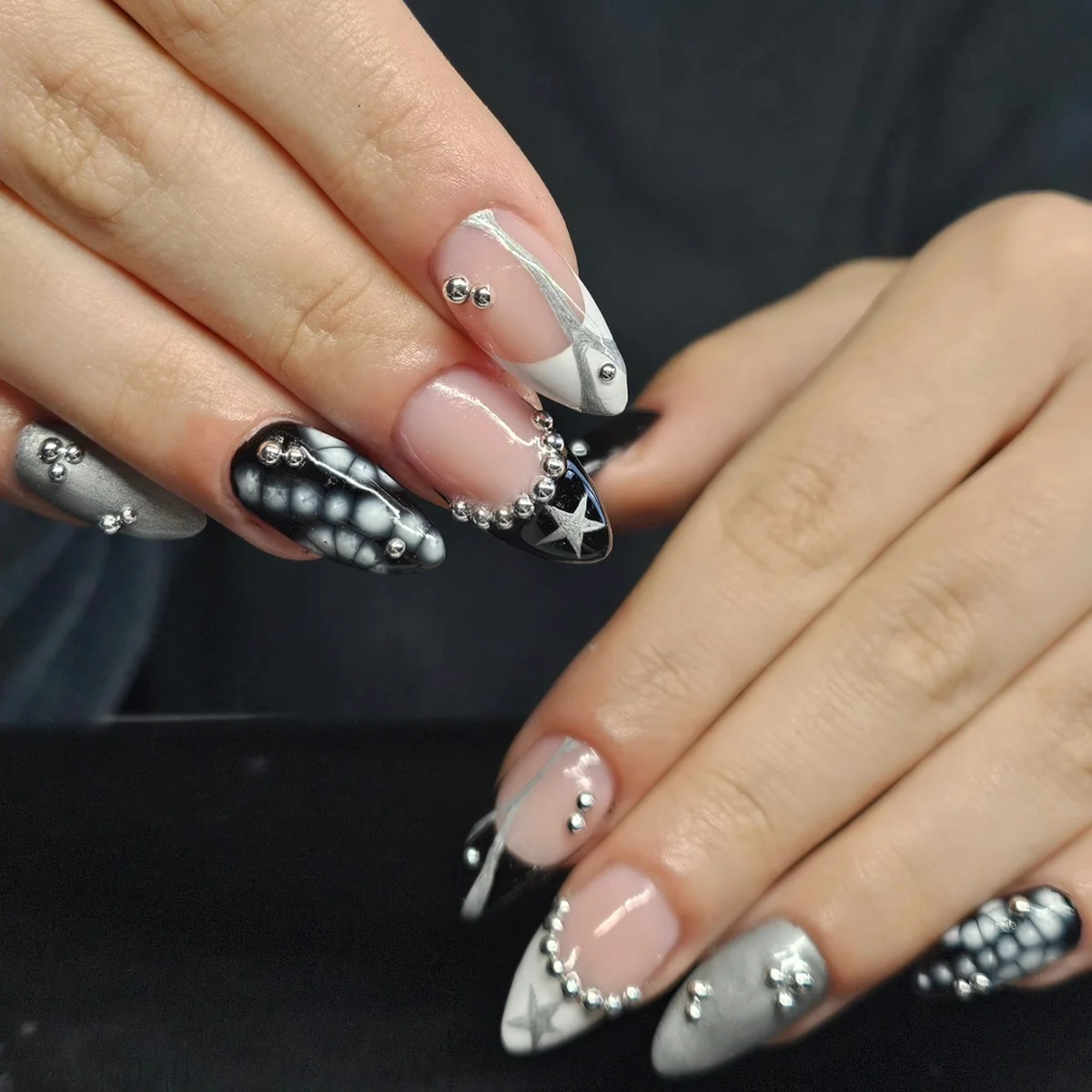 Nude, black and grey nails with white star and dotted details