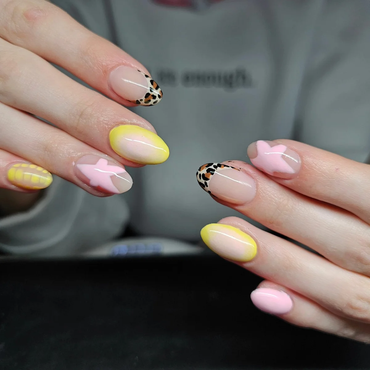 Nude nails with leopard-print tips, yellow accents and pale pink bows.
