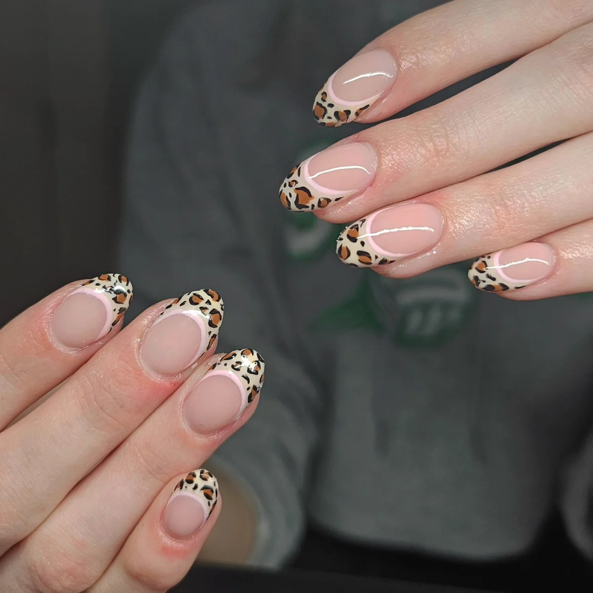 Nude almond nails with leopard-print French tips.