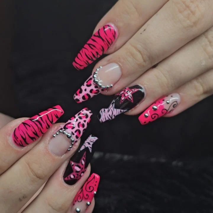 Long pink and black nails with animal prints, fine patterns and crystal accents.