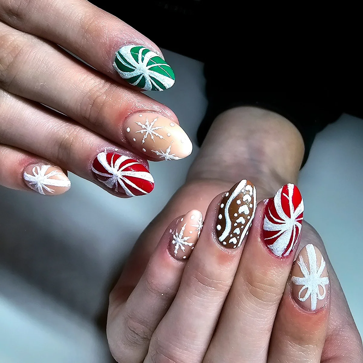 Red, green and nude nails with peppermint swirls, snowflakes and patterned accents.