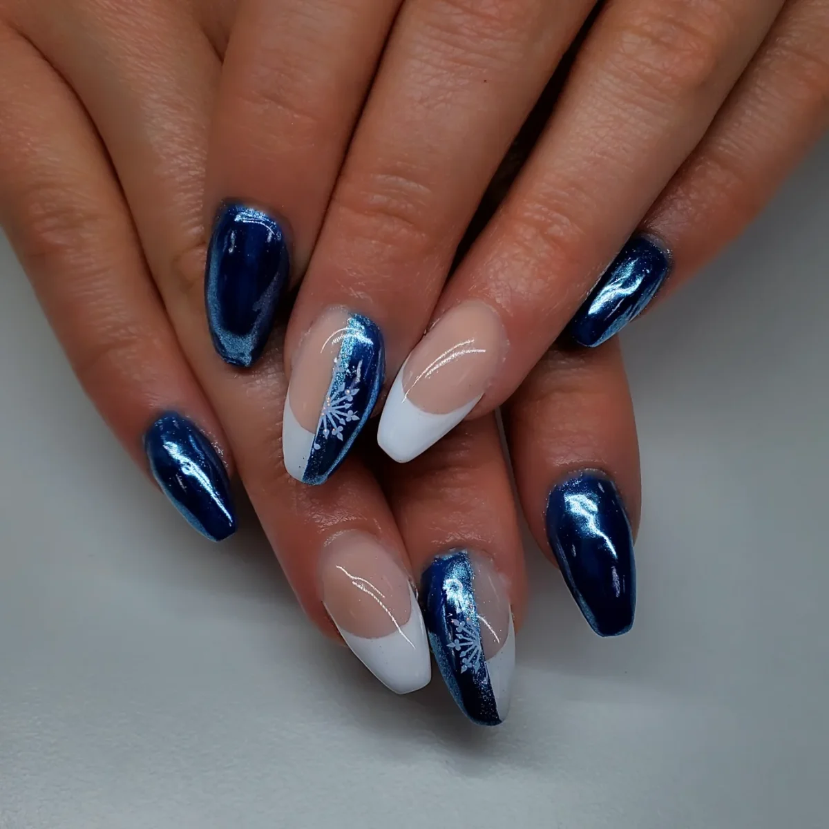 Deep blue metallic nails with white marbled accents