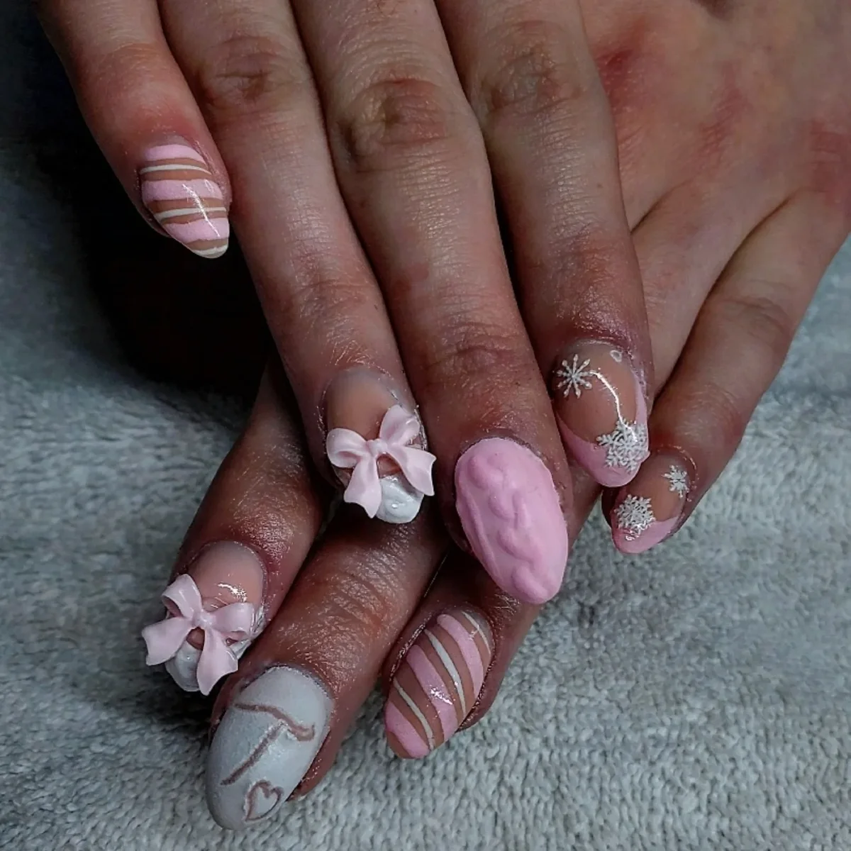 Pink and pale nails with raised flowers, curved stripes and fine white details.