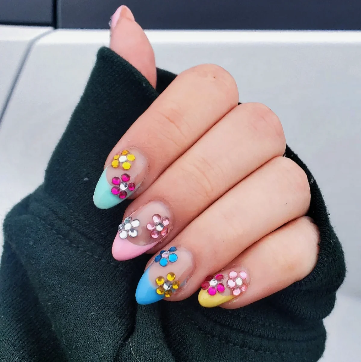 Pink, blue and nude nails with colourful raised flower accents.